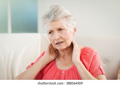 Senior Woman Suffering From Neck Pain At Home