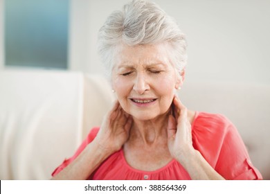 Senior Woman Suffering From Neck Pain At Home