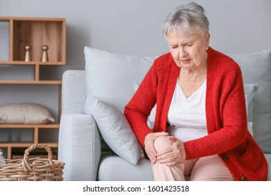 Senior Woman Suffering From Pain In Knee At Home