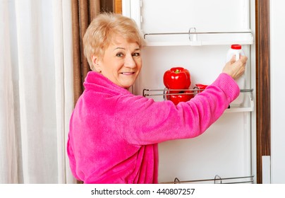 Senior Woman Taking A Bottle Of Milk From Fridge