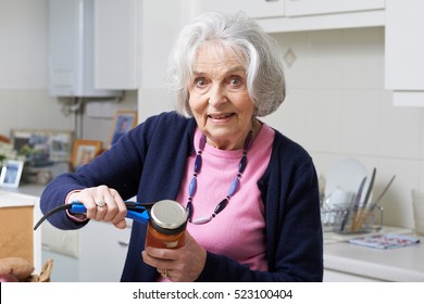 Senior Woman Taking Lid Off Jar With Kitchen Aid