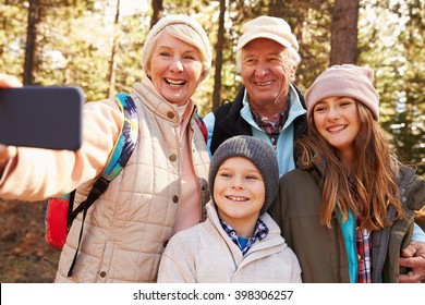 Senior Woman Taking Outdoor Selfie With Grandkids And Spouse