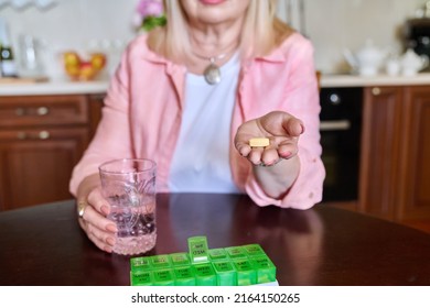 Senior Woman Taking Vitamins From Daily Pill Box