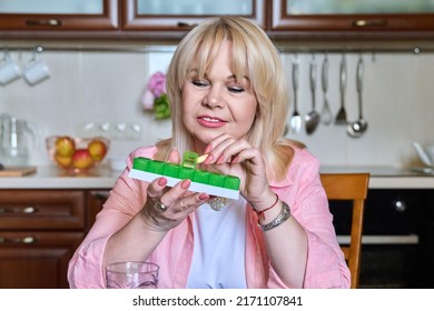 Senior Woman Taking Vitamins From Daily Pill Box