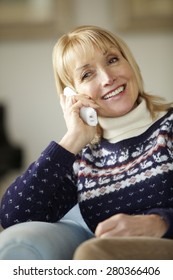 Senior Woman Talking On Cordless Phone At Home