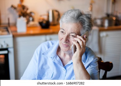 Senior Woman Talking On Mobile Phone At Home Kitchen. Telephone Call From Family To Retired Person. Pensioner In Social Distancing, Isolation. People Connection, Communication. Lifestyle Moment.