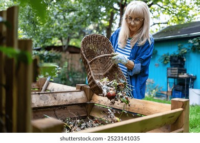 Senior woman throwing vegetable scraps into a compost heap in the backyard - Powered by Shutterstock