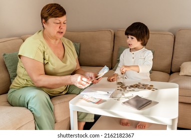 Senior Woman Together With Little Child Counting Money Americain Dollars And Euro At Home Teaching Kid Financial Literacy Planning Budget