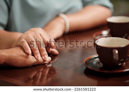 Senior woman touching hand of her husband, expressing love and support