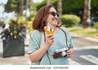 Senior Woman Tourist Holding Camera Eating Ice Cream At Street