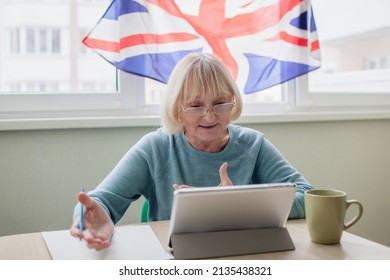 Senior Woman Trying To Learn English Via Internet With Laptop, Language Classes For Ukrainian Refugee For Better Adaptation Abroad, British Flag On The Window, Social Distance Education