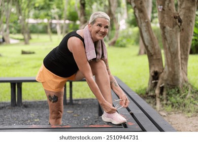 Senior woman tying shoelaces before outdoor workout - Powered by Shutterstock