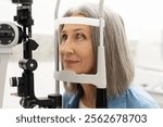 Senior woman undergoing an eye examination using a slit lamp, highlighting the importance of vision care and regular checkups for maintaining eye health. Vision care concept