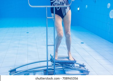 Senior Woman In Underwater Gymnastics Therapy With Sliding Machine