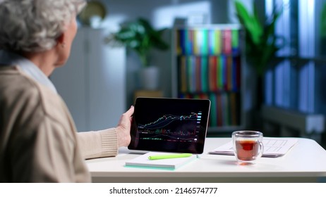 Senior woman use digital tablet with graph having online investment courses. Back view of elderly female watch financial literacy webinar on tablet pc - Powered by Shutterstock