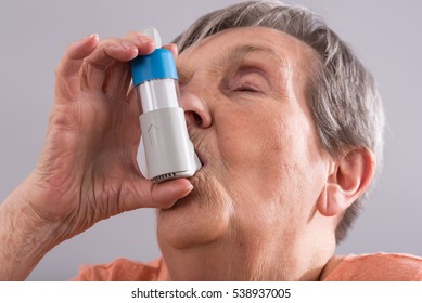 Senior Woman Using An Asthma Inhaler