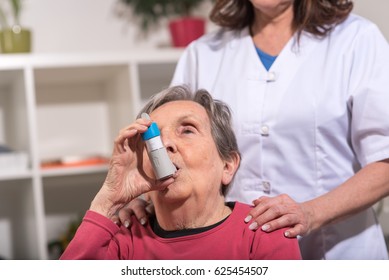 Senior Woman Using An Asthma Inhaler