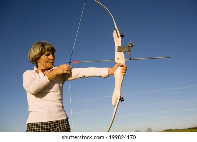 Senior woman using bow and arrow - Powered by Shutterstock