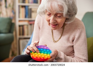 Senior Woman Using Colourful Fidget Toy To Improve Mental Stimulation At Home