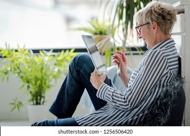 Senior Woman Using Digital Tablet At Home. The Use Of Technology By The Elderly