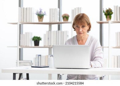 Senior Woman Using Laptop Computer And Serious At Work