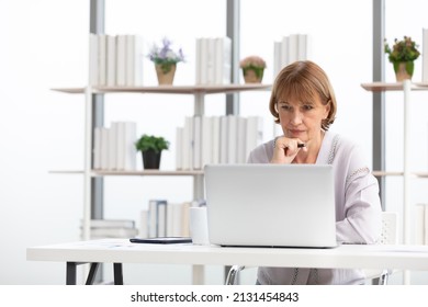 Senior Woman Using Laptop Computer And Serious At Work