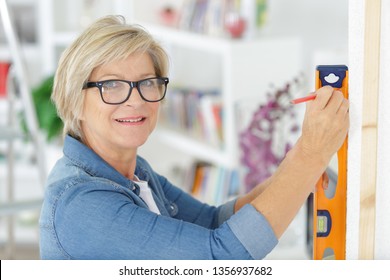 Senior Woman Using Leveling Tool At Home