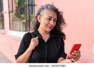 Senior Woman Using Mobile Phone In The Street - Shutterstock ID 2255927083