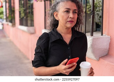 Senior Woman Using Mobile Phone In The Street - Shutterstock ID 2255927097