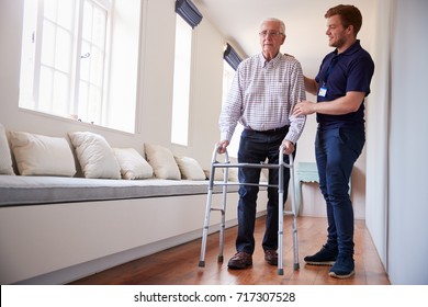 Senior woman using a walking frame with male nurse at home