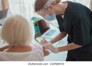 Senior Woman Visited By District Nurse At Home