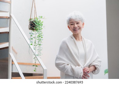 Senior woman walking up and down stairs in good spirits - Powered by Shutterstock