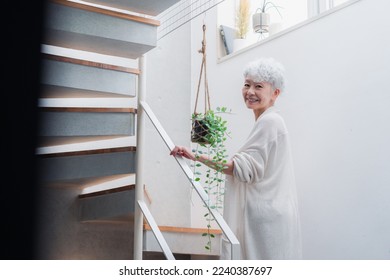 Senior woman walking up and down stairs in good spirits - Powered by Shutterstock