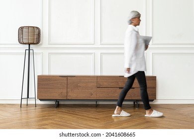 Senior Woman Walking In Scandinavian Living Room