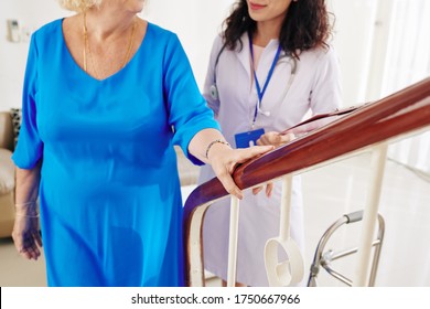 Senior Woman Walking Up The Stairs Under Control Of Her Physician