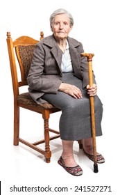 Senior Woman With Walking Stick Sitting On Chair Over White Background 