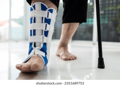 Senior woman walking,her leg wearing foot support or ankle brace reduce pressure on the affected foot and support for ankle sprain,problems of ligaments,bone fracture,ankle joint are stretched or torn - Powered by Shutterstock