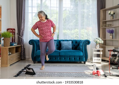 Senior woman warm up her leg with tablet in training exercise online, workout online from home concept