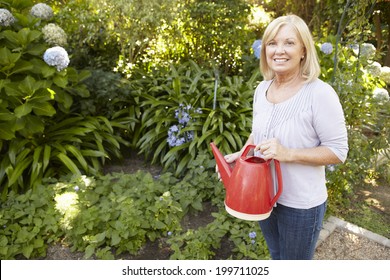 Senior Woman Watering Garden