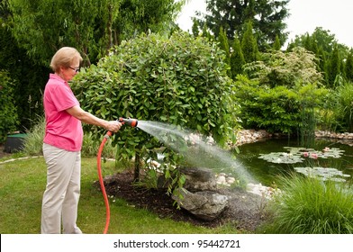 Senior Woman Watering Garden