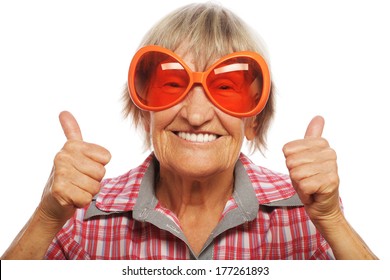 Senior woman wearing big sunglasses doing funky action isolated on white background 