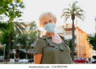 Senior Woman Wearing A Blue Surgical Mask In The Street