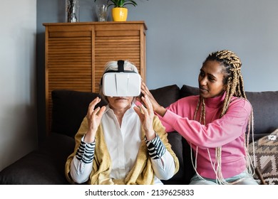 Senior Woman Wearing Virtual Reality Headset At Home - Multiracial People Using Metaverse Tech - Focus On African Girl Face