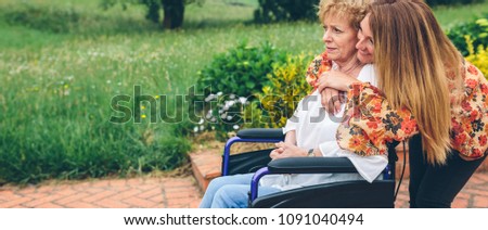 Similar – Granddaughter hugging grandmother in wheelchair