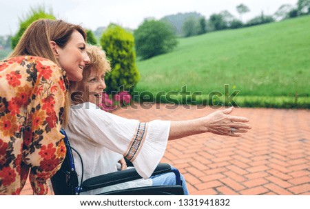 Senior dissatisfied woman in a wheelchair with her daughter