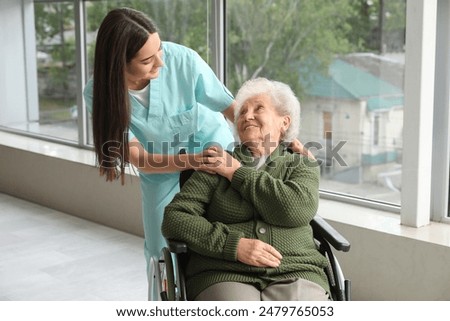 Doctor talking to elderly patient in a wheelchair