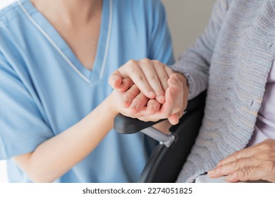 Senior woman in wheelchair indoors with Female Healthcare Professional Hand - Powered by Shutterstock