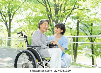 Senior woman in wheelchair indoors with Female health care worker in her 30s - Powered by Shutterstock