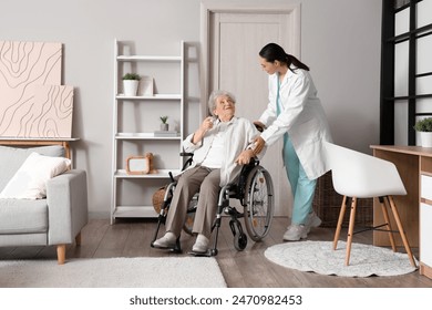 Senior woman in wheelchair with physical therapist at home - Powered by Shutterstock