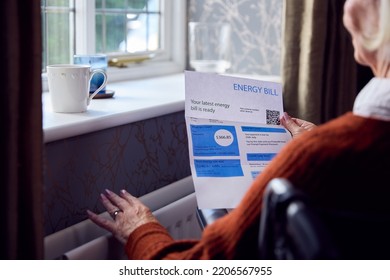 Senior Woman In Wheelchair With USA Energy Bill By Radiator In Cost Of Living Energy Crisis